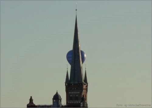 St.Petri-Kirche in Lübeck mit blauem Heißluftballon hinter Turmspitze reisend