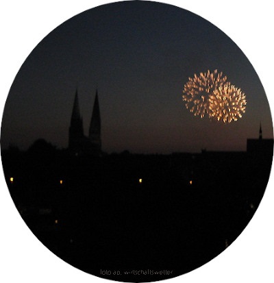 Silhouette der Marienkirche in Lübeck in Abenddämmerung mit Feuerwerk